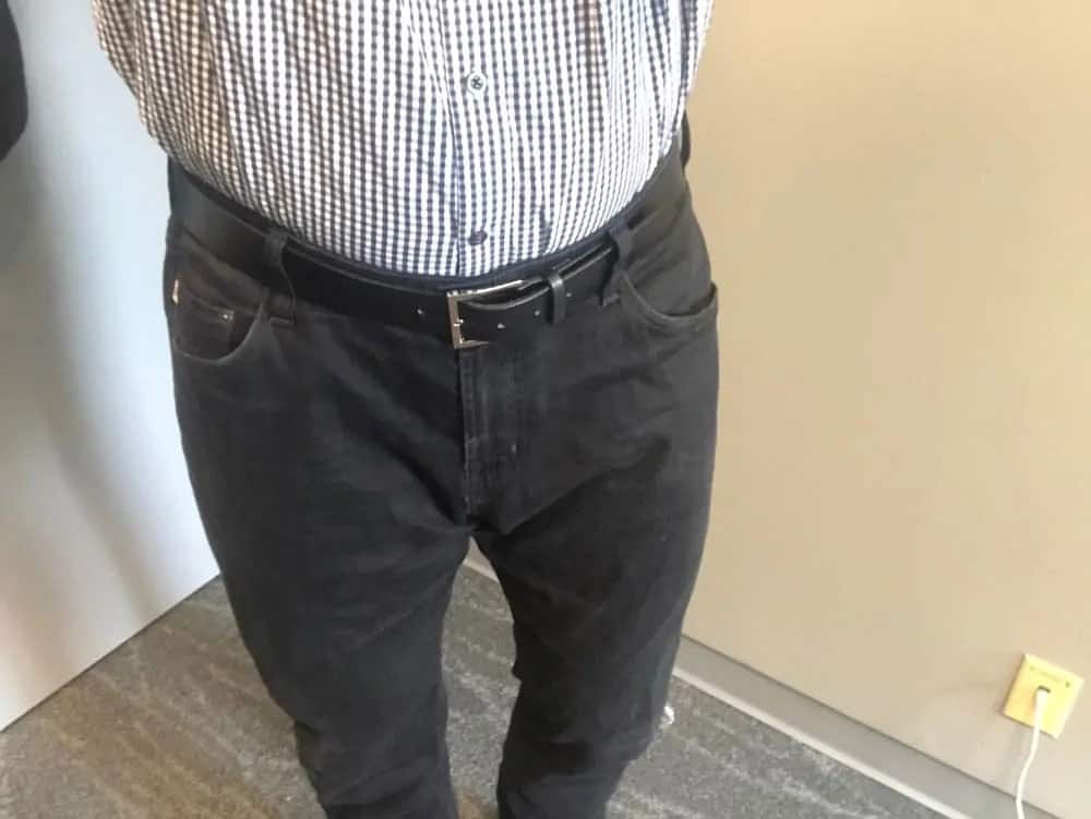Black AG jeans for men with shirt tucked.