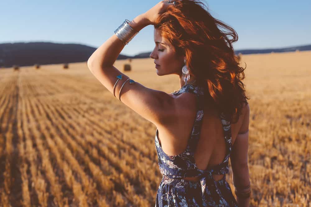 Model with armlets posing in autumn field.