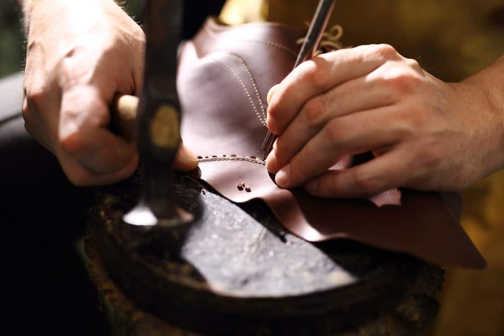 Shoemaker stitching a boot.