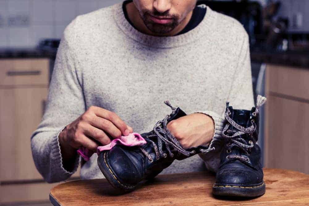 Man is polishing his boots.