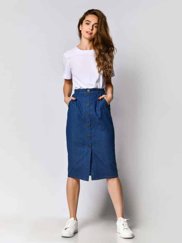 Lady with her hands on the side pockets of her button up skirt.