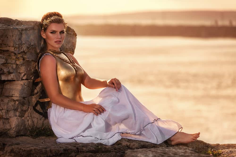 Model in a goddess outfit with gold crown.