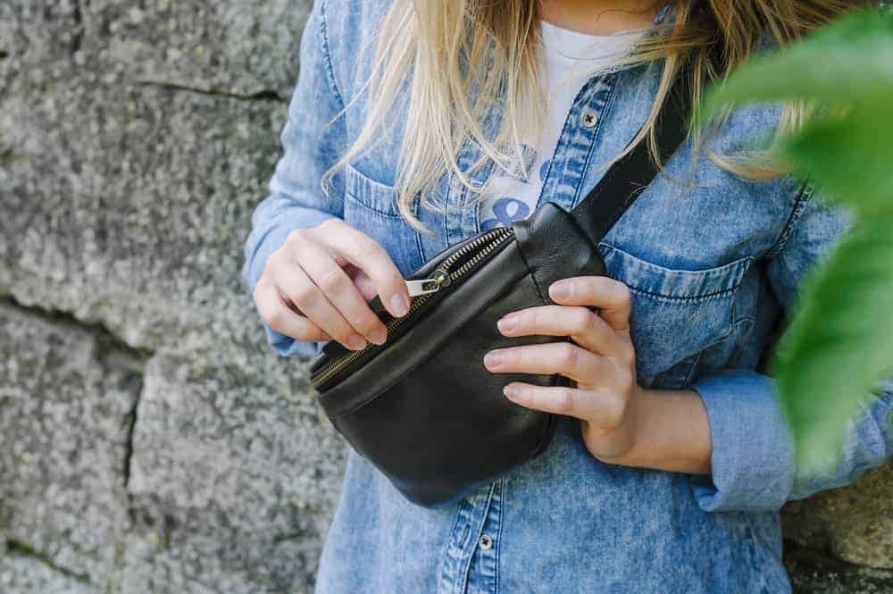 Women wearing a denim jacket and a black fanny pack.