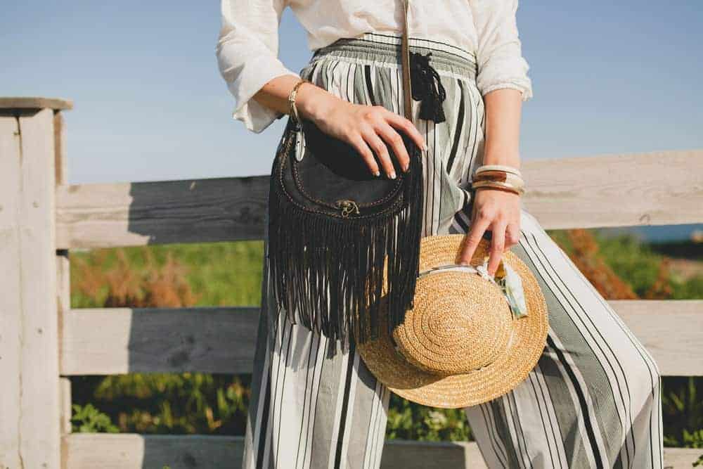Woman in boho outfit with a half moon bag.