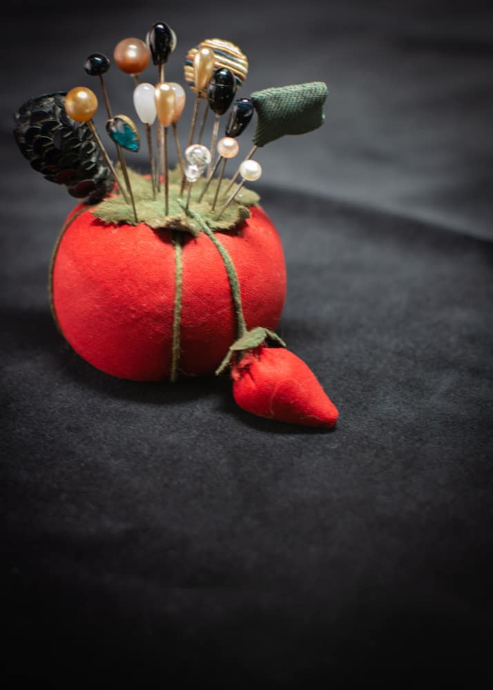 Red pin cushion with hatpin assortment.