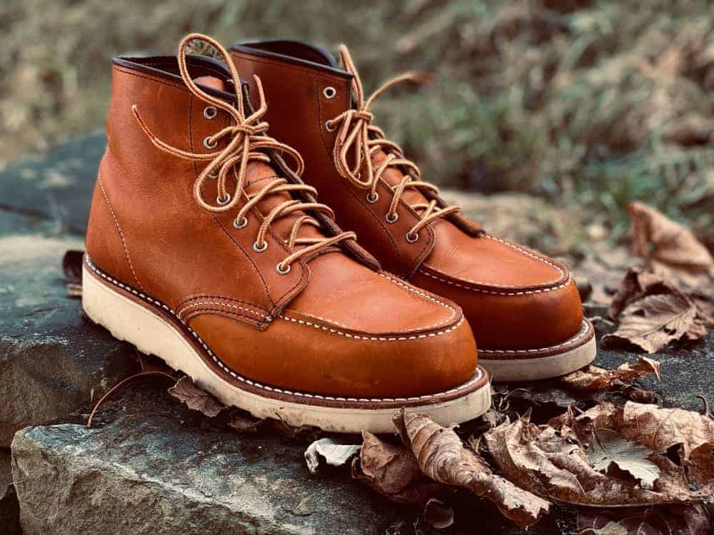 Moc toe brown leather shoes resting on large rocks.