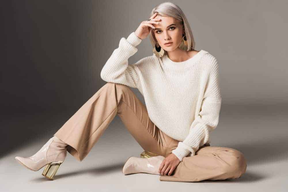 Woman posing in white trendy sweater.