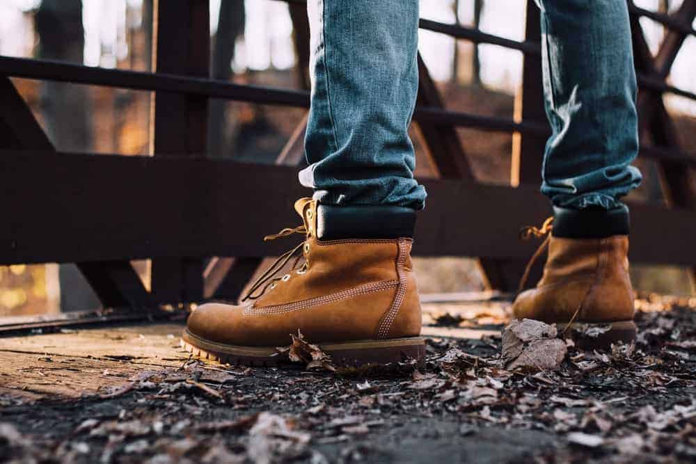 A man in work boots standing on the bridge.