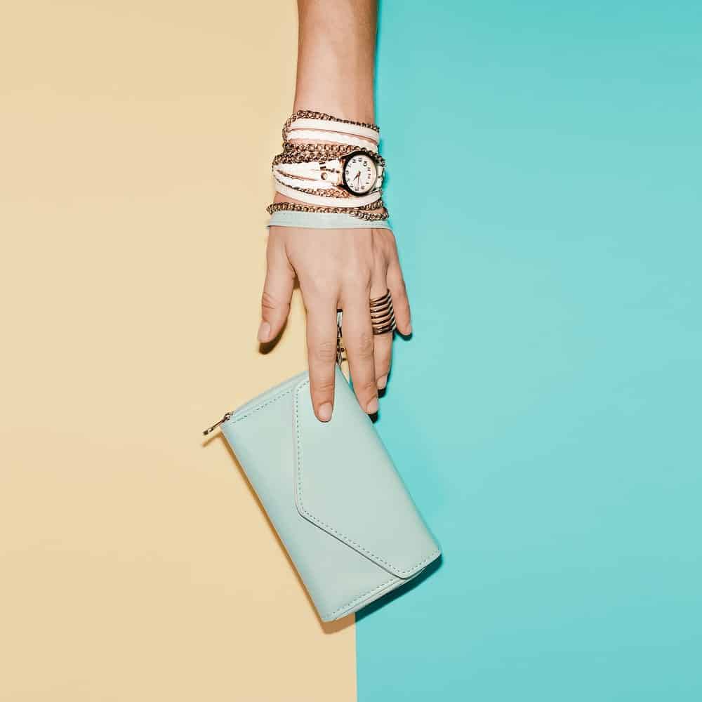 Hand wearing watch, bracelets, and wristlets.