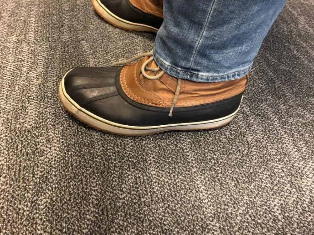 Side view of Sorel Caribou boots with jeans untucked.