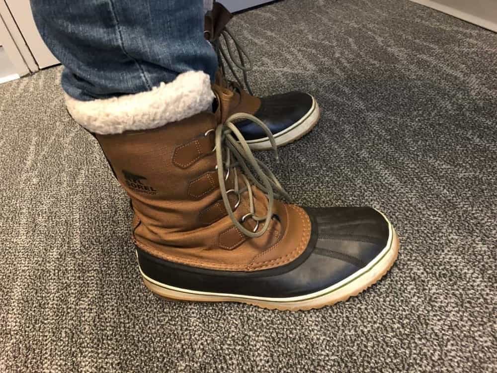Side view of Sorel Caribou boots with jeans tucked inside.