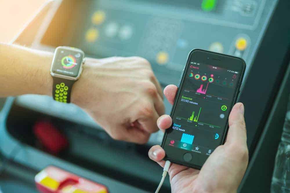 A man synchronizing his phone and apple watch.