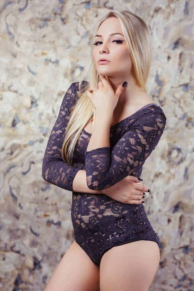A woman sporting a purple lace bodystocking.