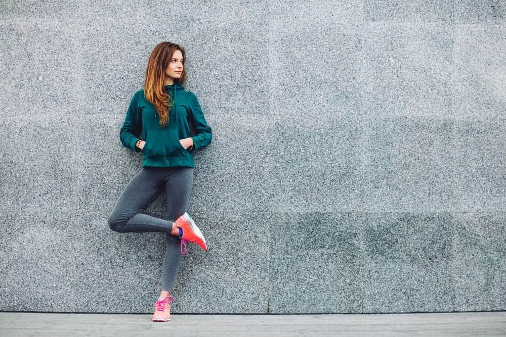 A woman wearing yoga pants and a sporty casual outfit.