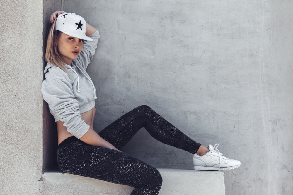 A woman modeling a pair of yoga pants with her sporty and sexy casual outfit.