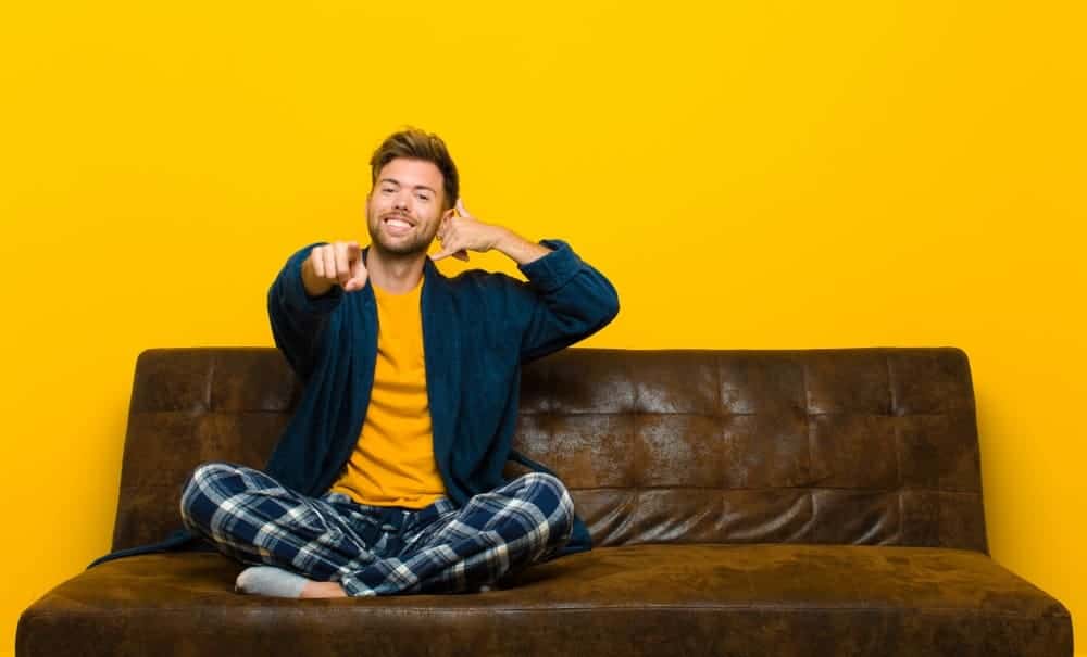A man wearing loungewear on the sofa.