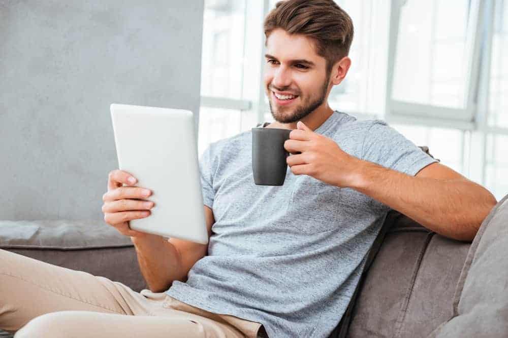 A man wearing slacks and shirt on the sofa.