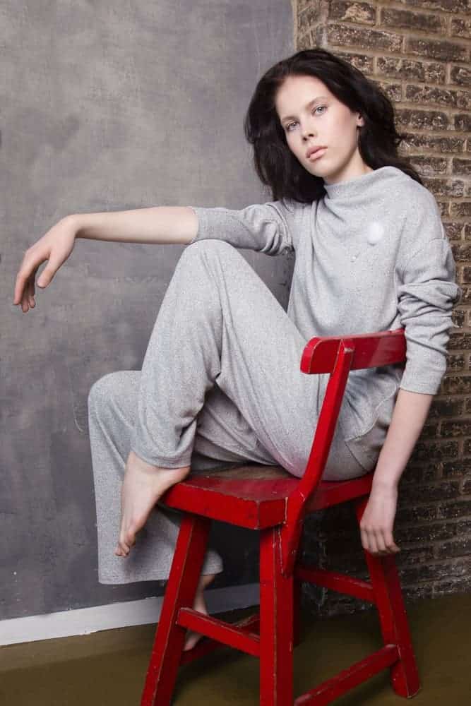A woman relaxing at home wearing a pair of sweats.