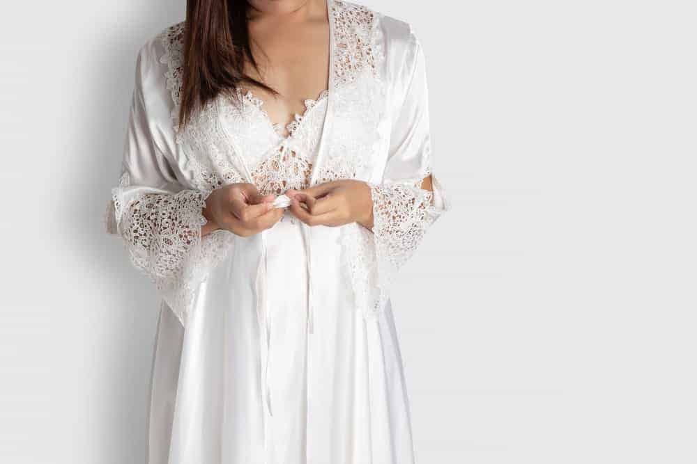 A woman wearing a white silk night gown.