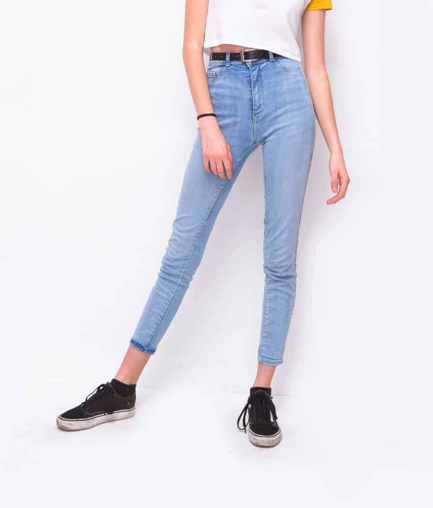 A woman wearing a pair of high waist skinny jeans with her white shirt.