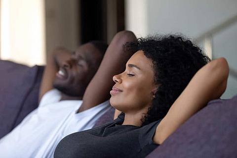 Man and woman lounging on sofa