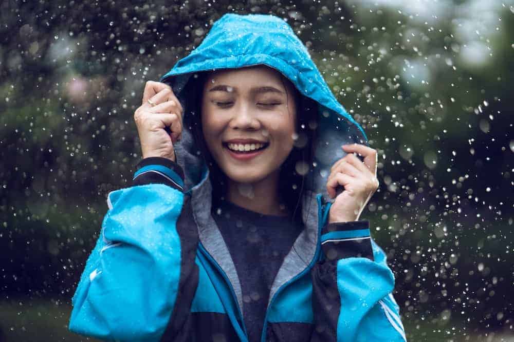 A woman wearing a blue rain jacket.