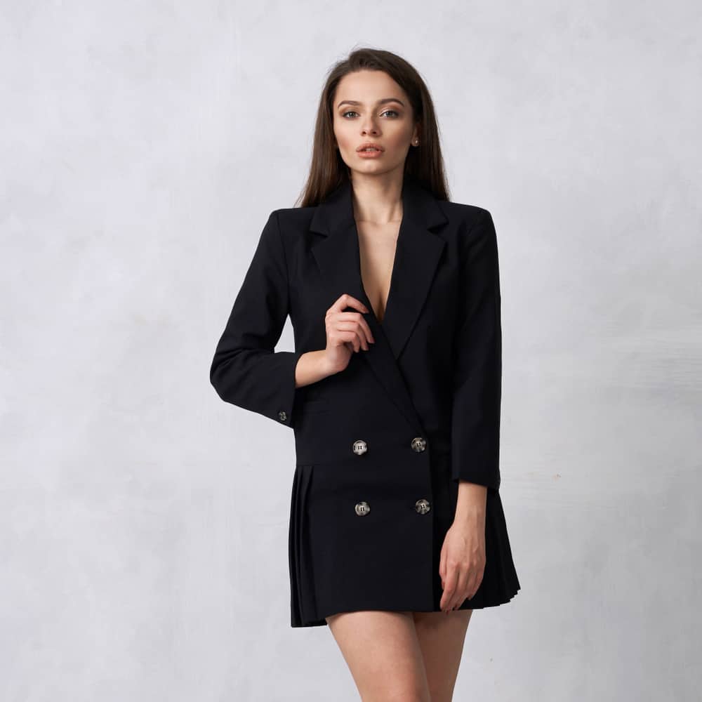 Woman wearing a black mini blazer dress.