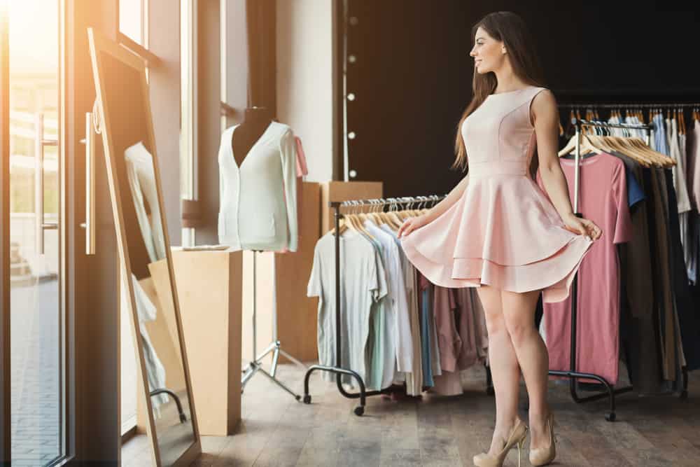 Woman trying on new dress in showroom.
