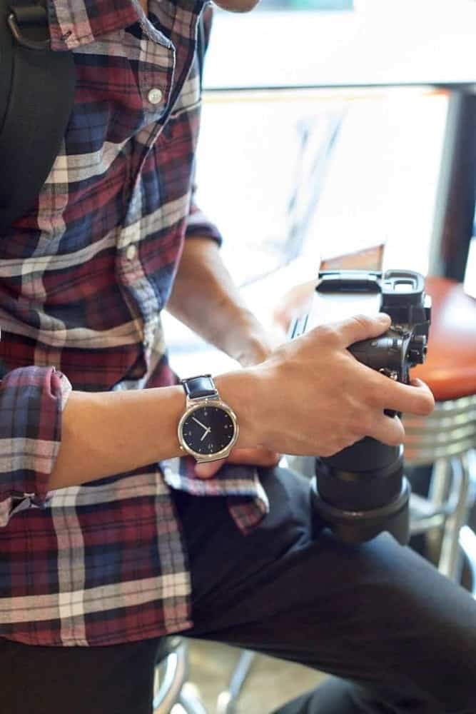 A man wearing a Huawei smartwatch showing the clock.