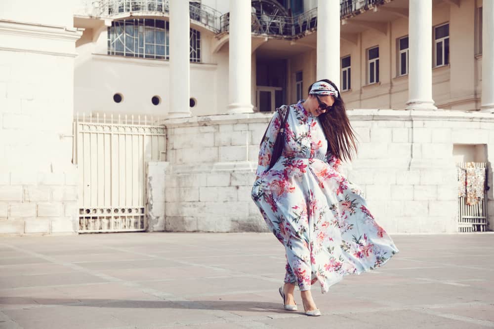 Woman in a floral maxi dress walking down the street.