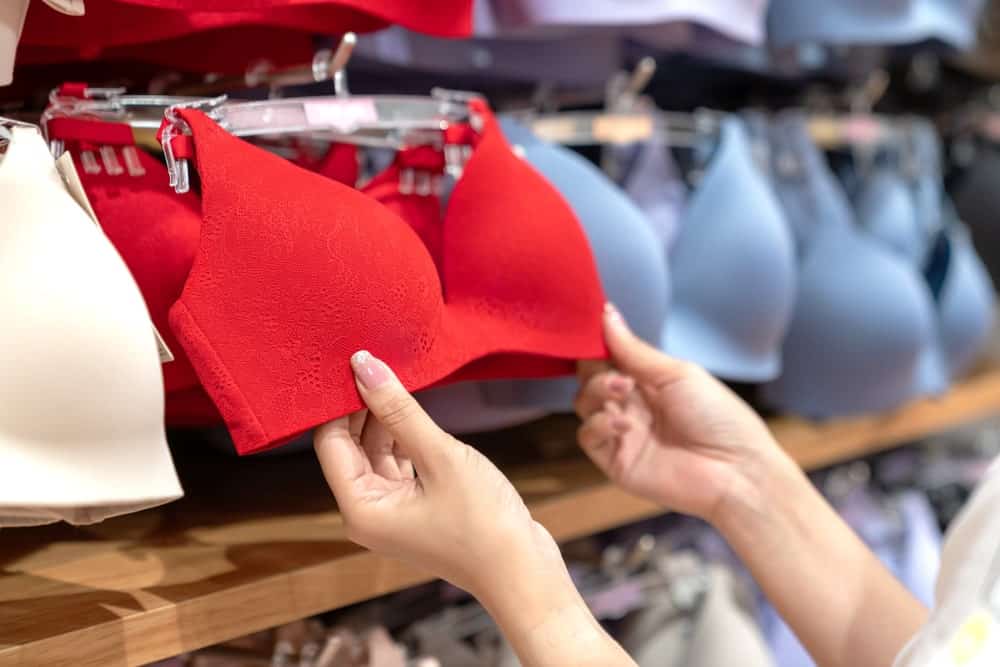 A woman browsing through bras on display.