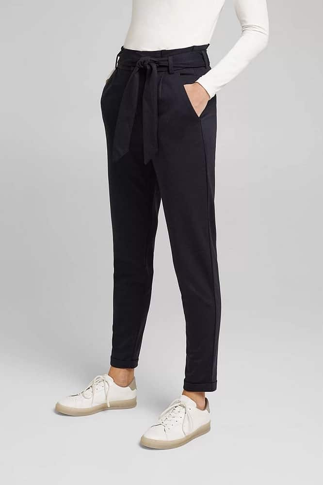 A woman wearing a pair of dark jersey chinos.