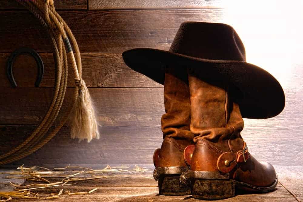 A pair of leather cowboy boots with a cowboy hat.