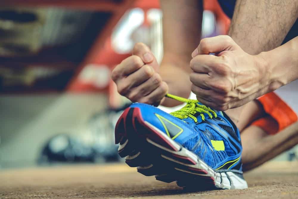 A close look at a man tying his shoes.