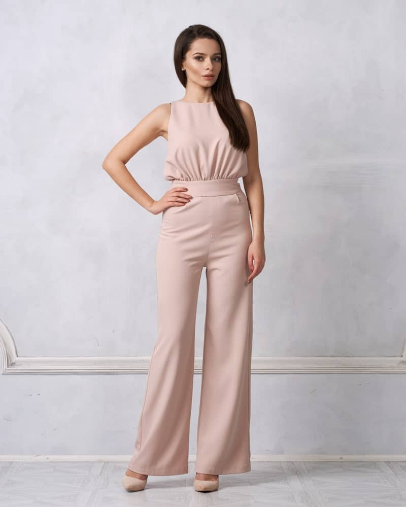 A woman wearing an elegant nude jumpsuit.
