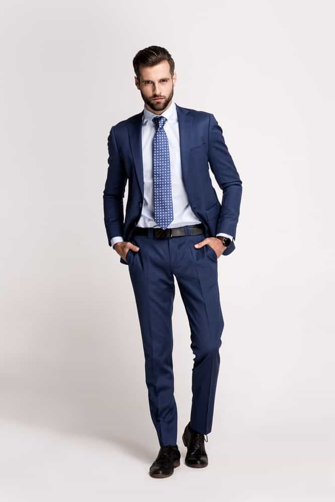 A man wearing a formal suit with slim pants.