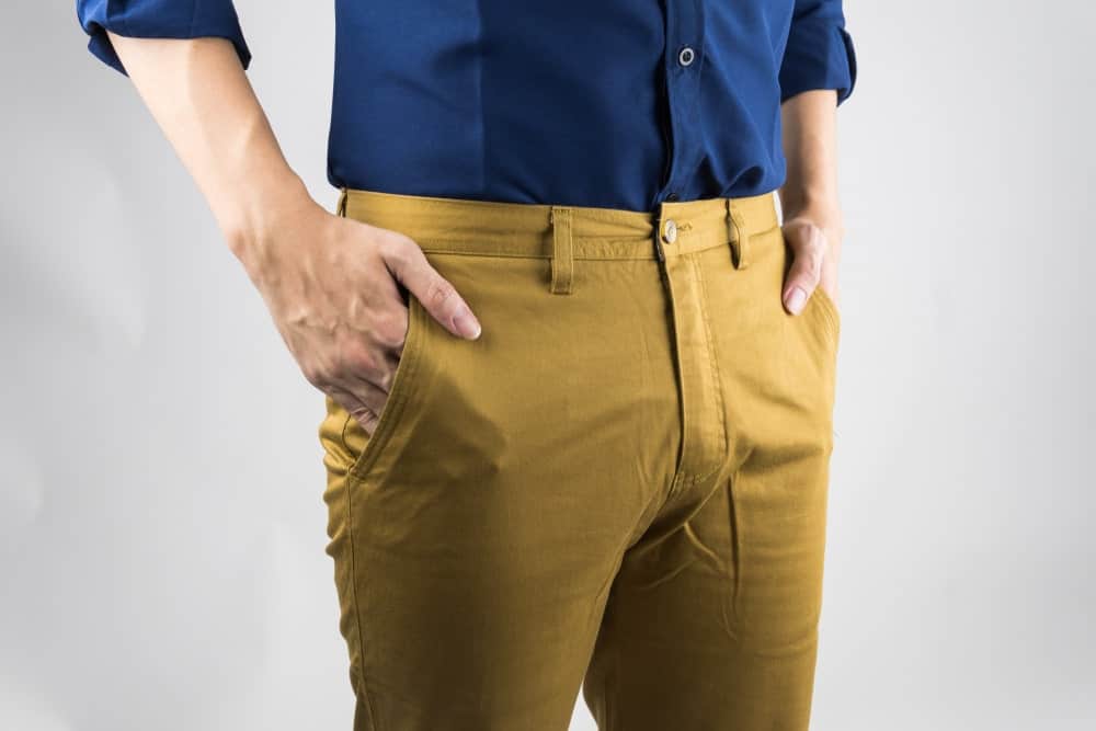 A close look at a man wearing a pair of yellow chinos.