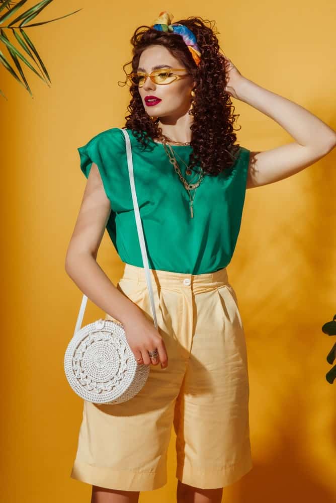 A woman with a green blouse and yellow long shorts.