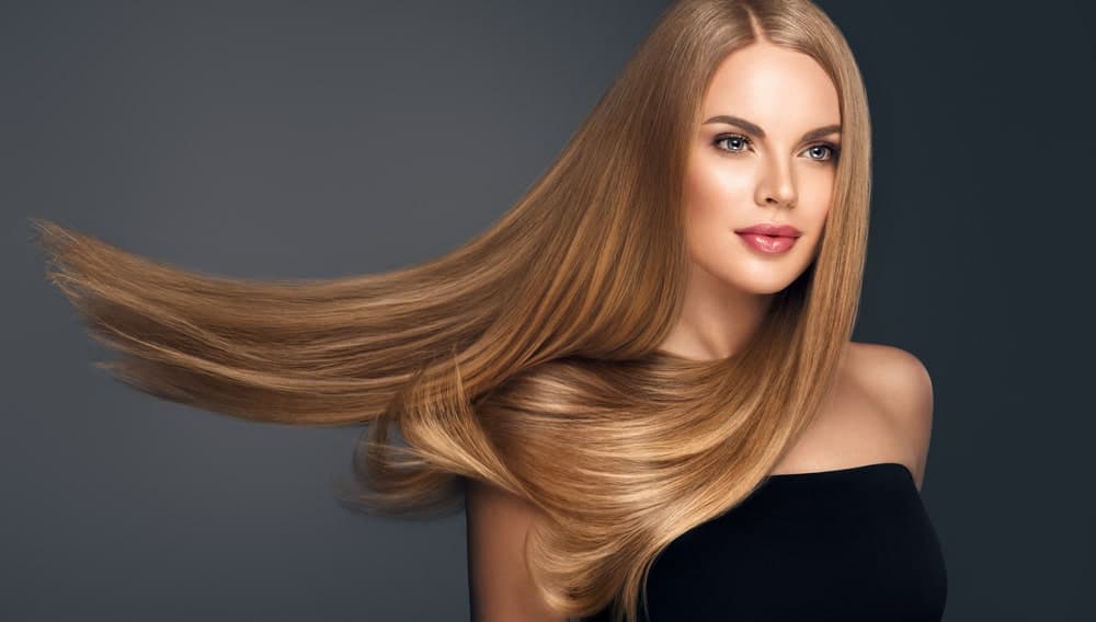 This is a close look at a woman wearing a long and straight brown wig.
