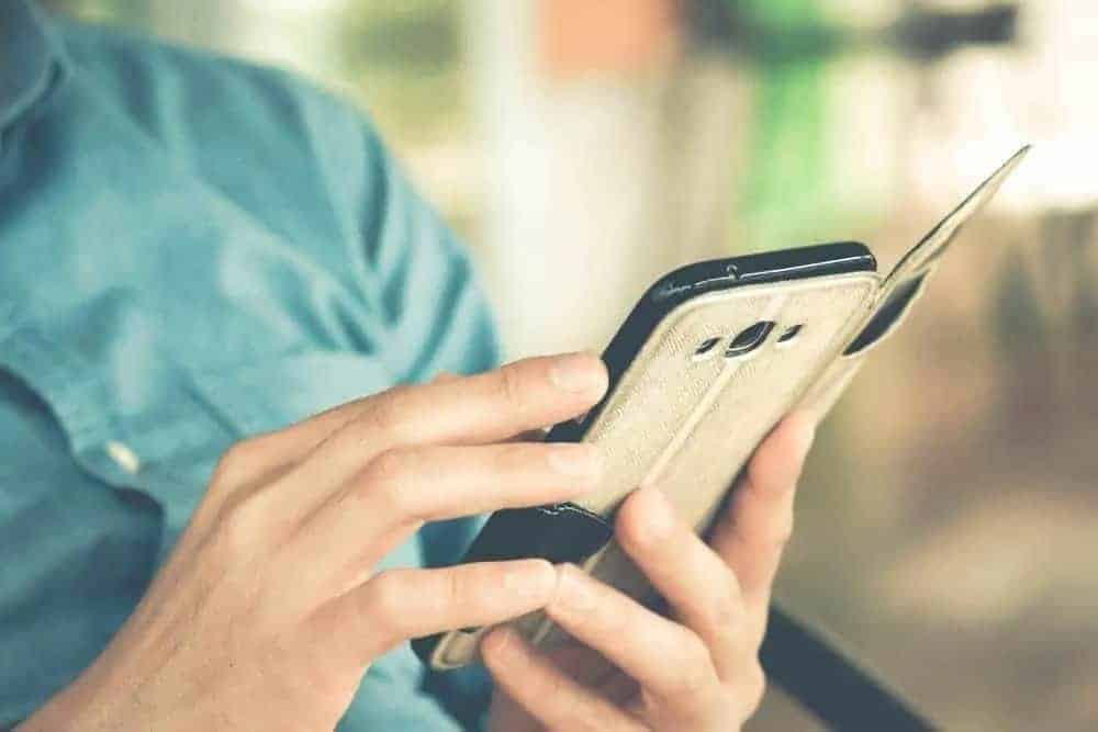 Man holding smartphone with vintage case.