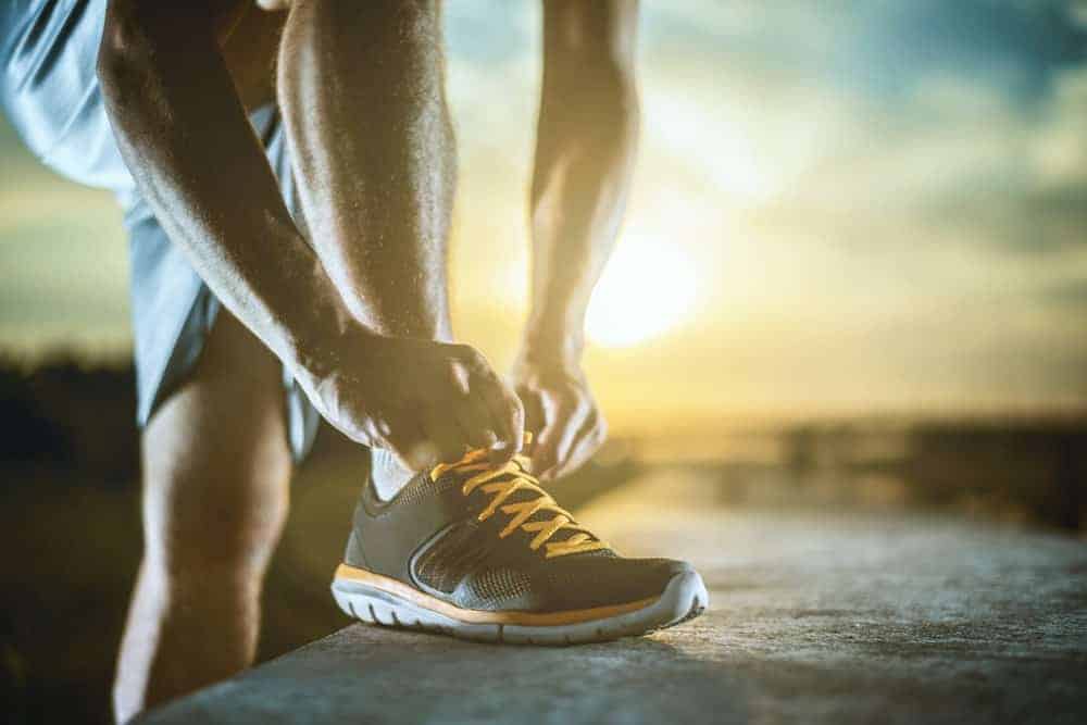 This is a close look at a man tying the laces of his running shoes.