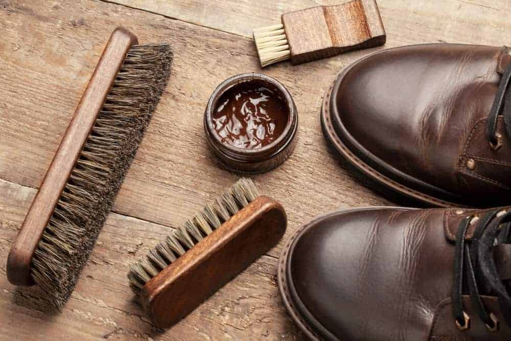 A can of cream polish with a pair of leather shoes.