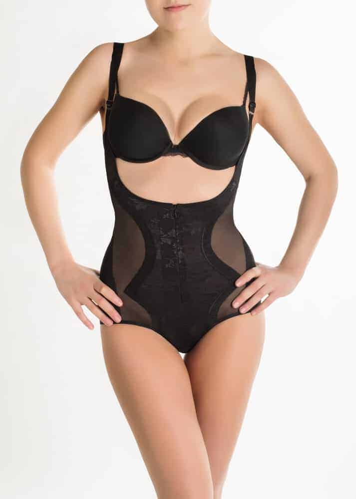 A woman wearing a a set of black shapewear underwear.