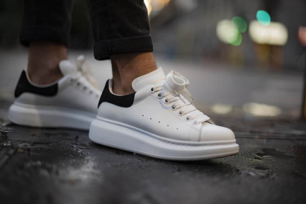 Man wearing a pair of Alexander McQueen sneakers in the street.