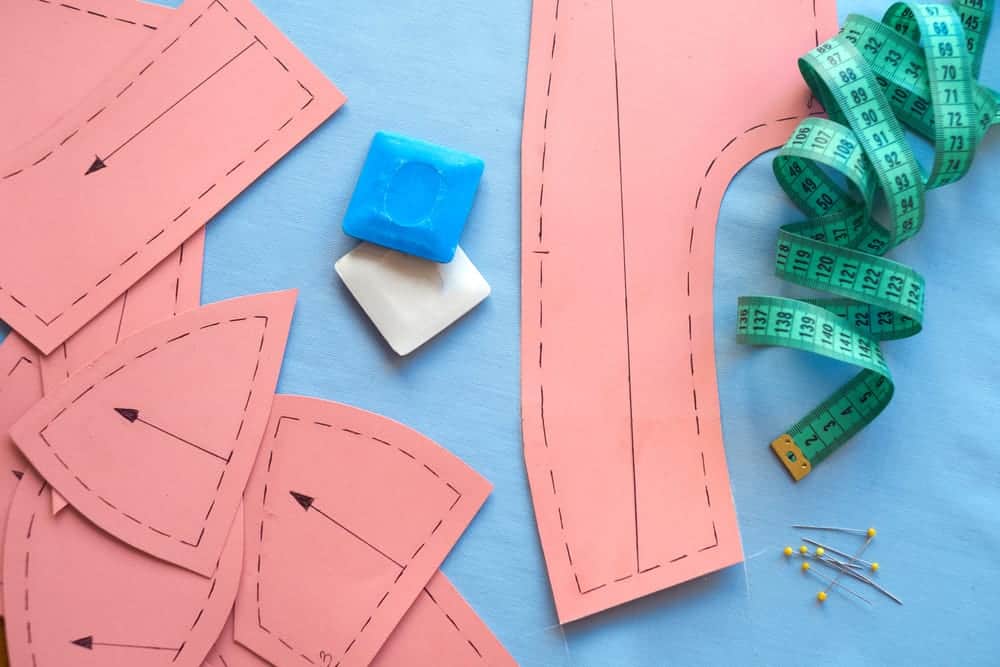 Sewing pattern and tools on a blue fabric.