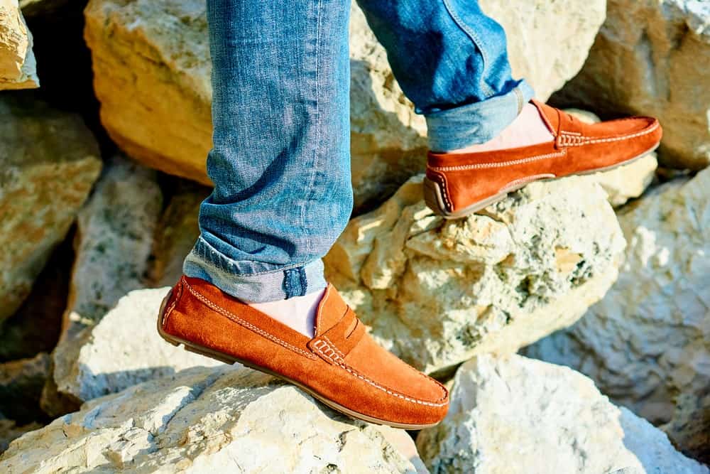 A man wearing a pair of loafers with his jeans.