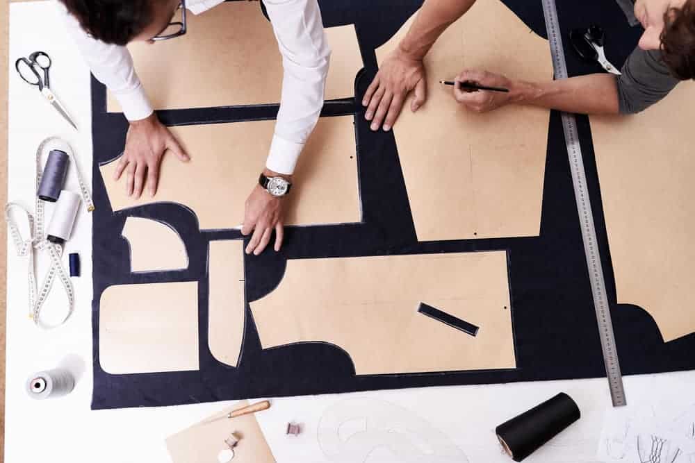 Tailors using sewing patterns.