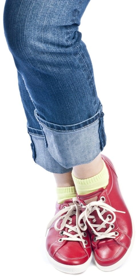 A close look at a woman with long cuffs on her jeans.