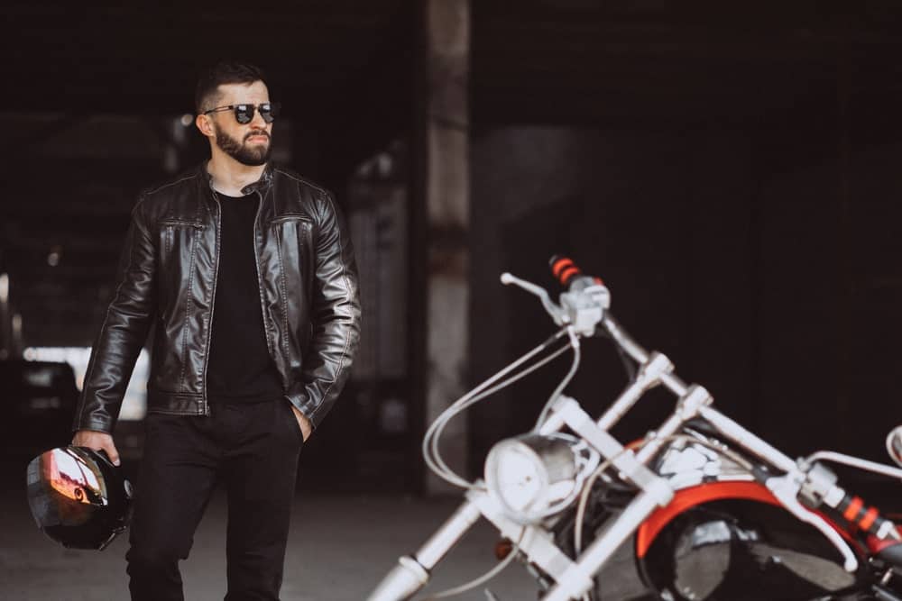 This is a close look at a man wearing a black leather biker jacket.