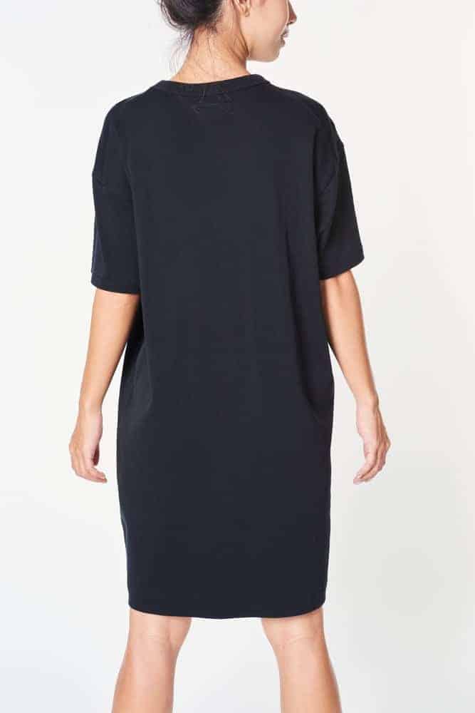 A close look at the back of a woman wearing a black dress with drop shoulder sleeves.